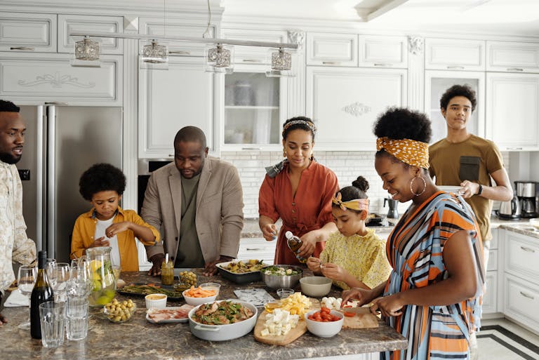 A happy family gathers in the kitchen to prepare a delicious meal together, fostering togetherness and joy.