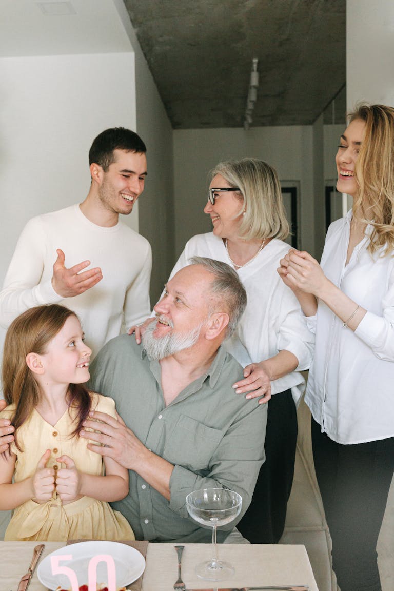 A joyful family gathering indoors celebrating a significant milestone with smiles and conversation.