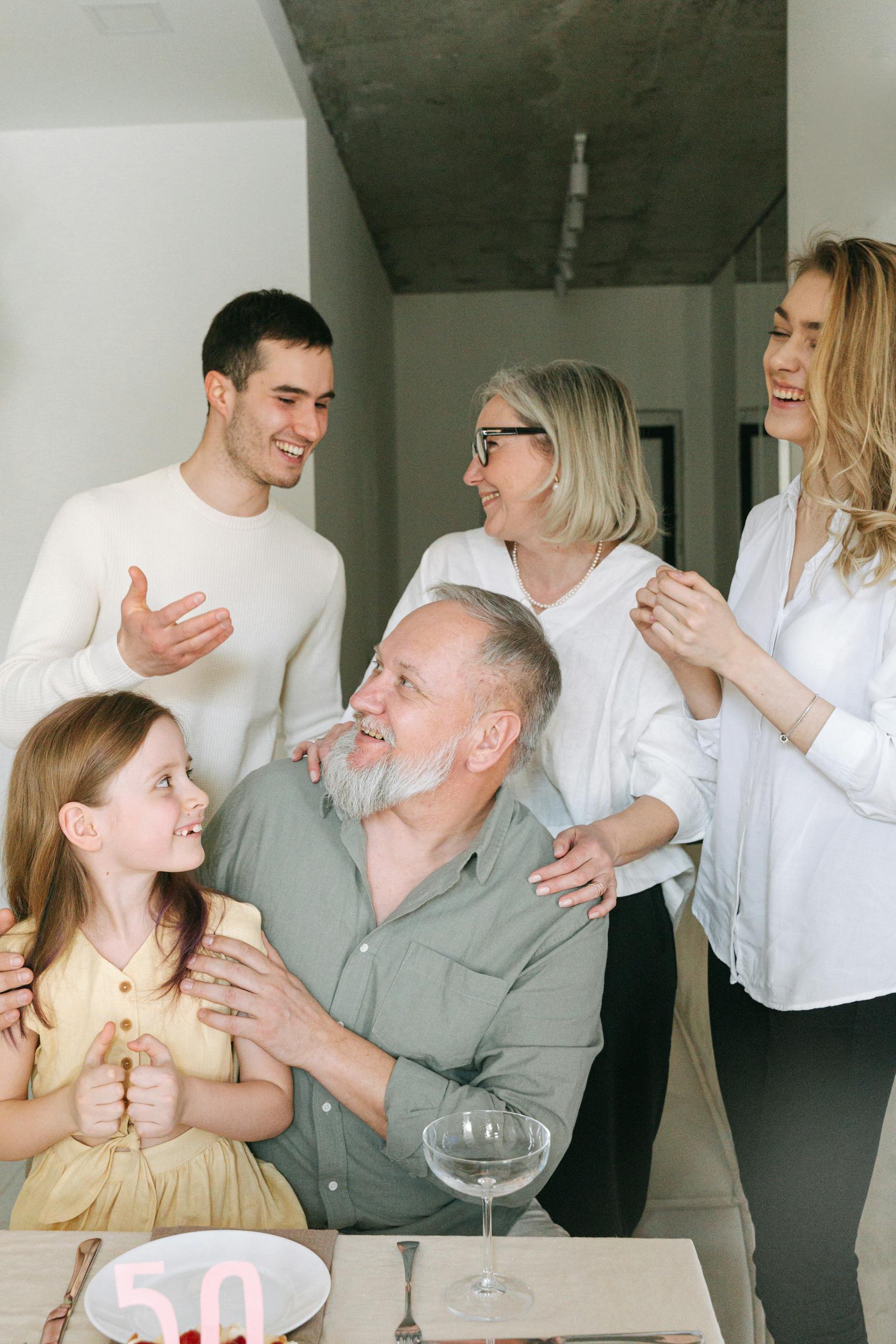 A joyful family gathering indoors celebrating a significant milestone with smiles and conversation.