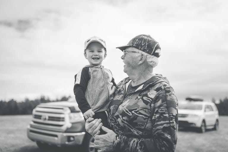 A joyful moment between grandfather and grandson in the outdoors, capturing laughter and togetherness.