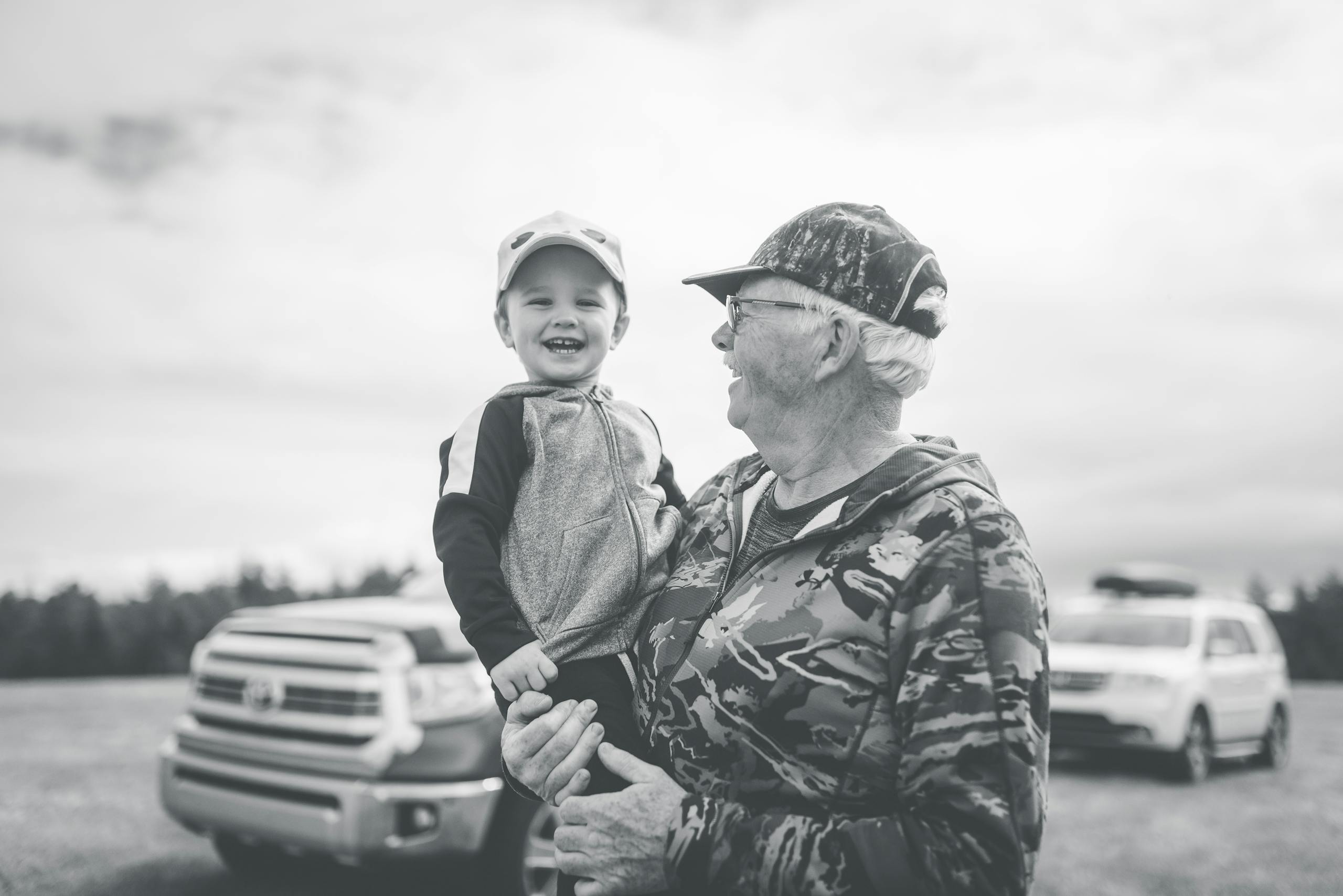 A joyful moment between grandfather and grandson in the outdoors, capturing laughter and togetherness.
