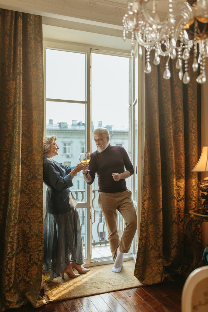 A senior caucasian couple toasting with wine in a luxurious home setting, reflecting love and elegance.