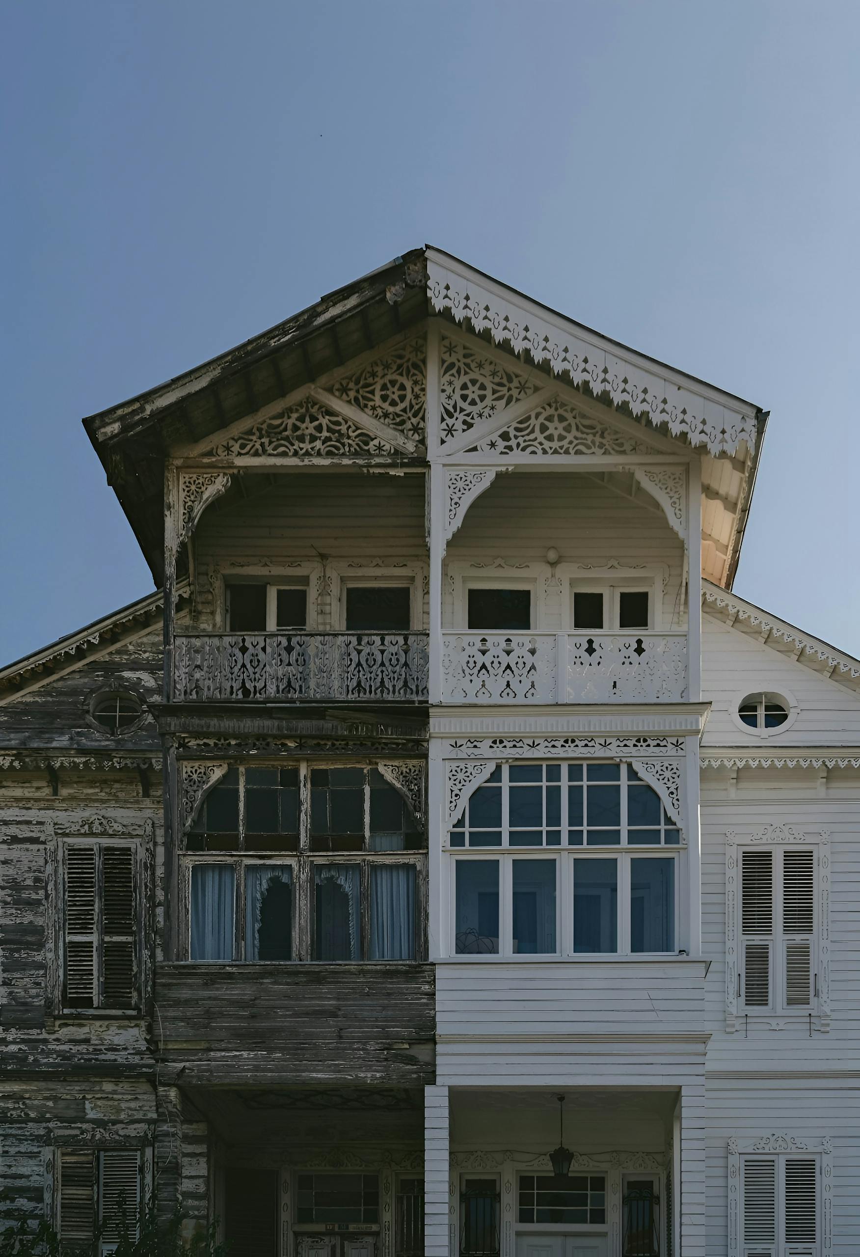 A split view of an old versus restored wooden house facade in Istanbul, showcasing contrast.