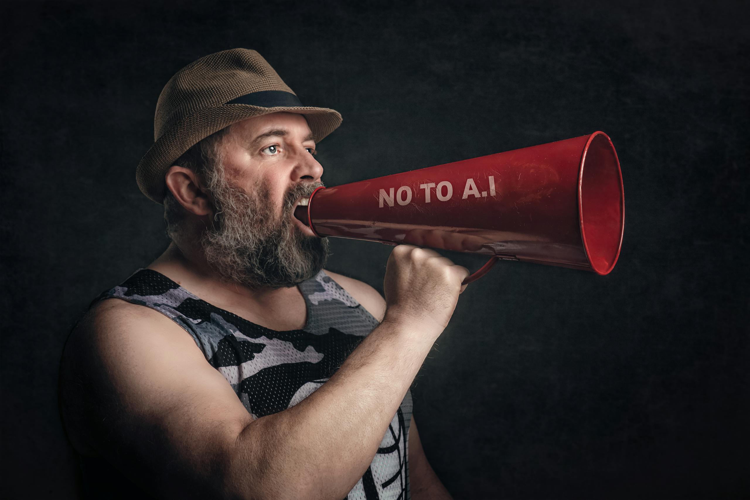 Bearded man shouting through a red megaphone with 'No to A.I' message.