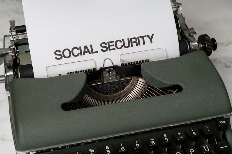Close-up of a vintage typewriter typing 'SOCIAL SECURITY' on paper.