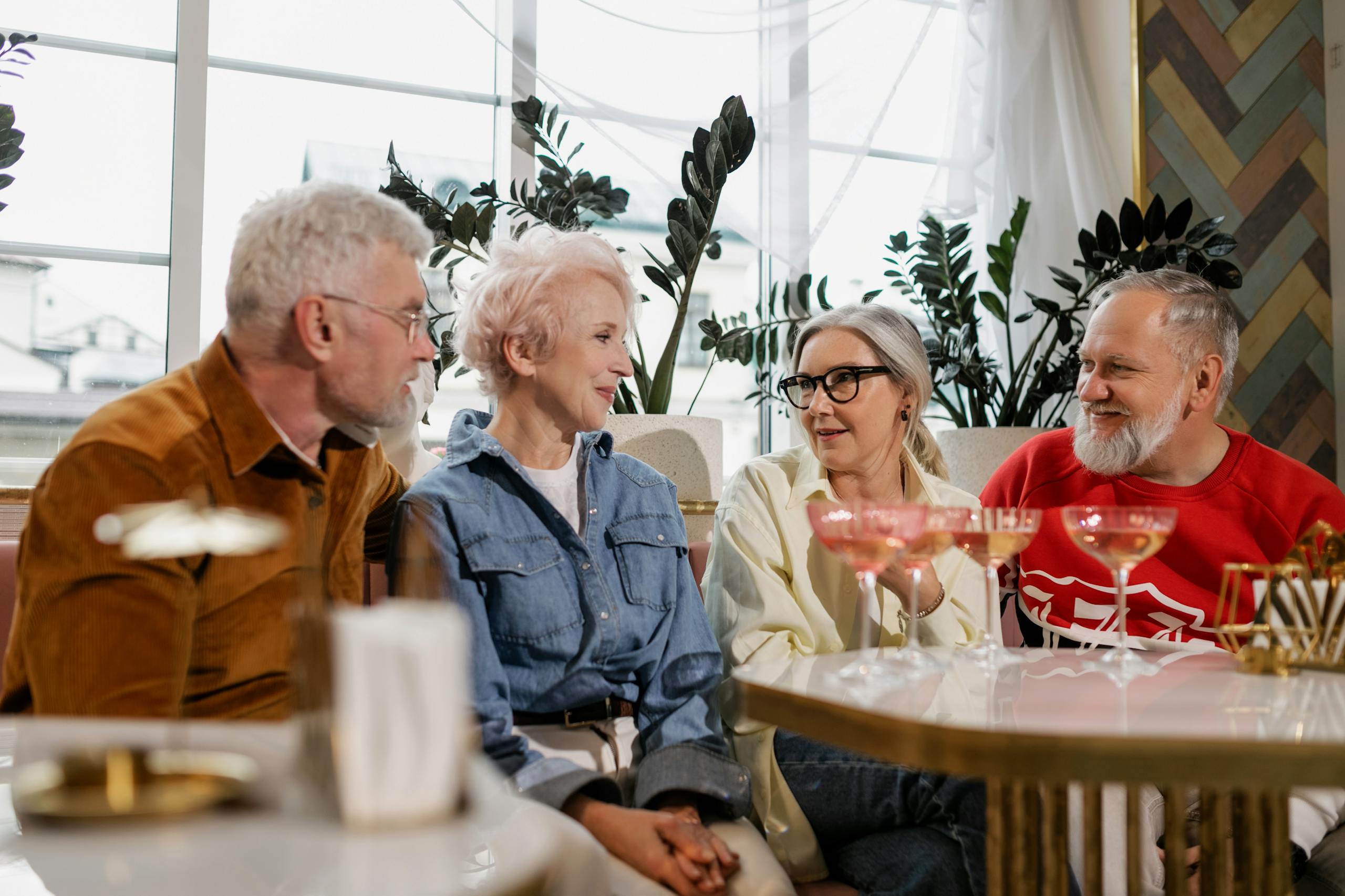 Close-up of senior adults having a joyful conversation at a social gathering indoors.