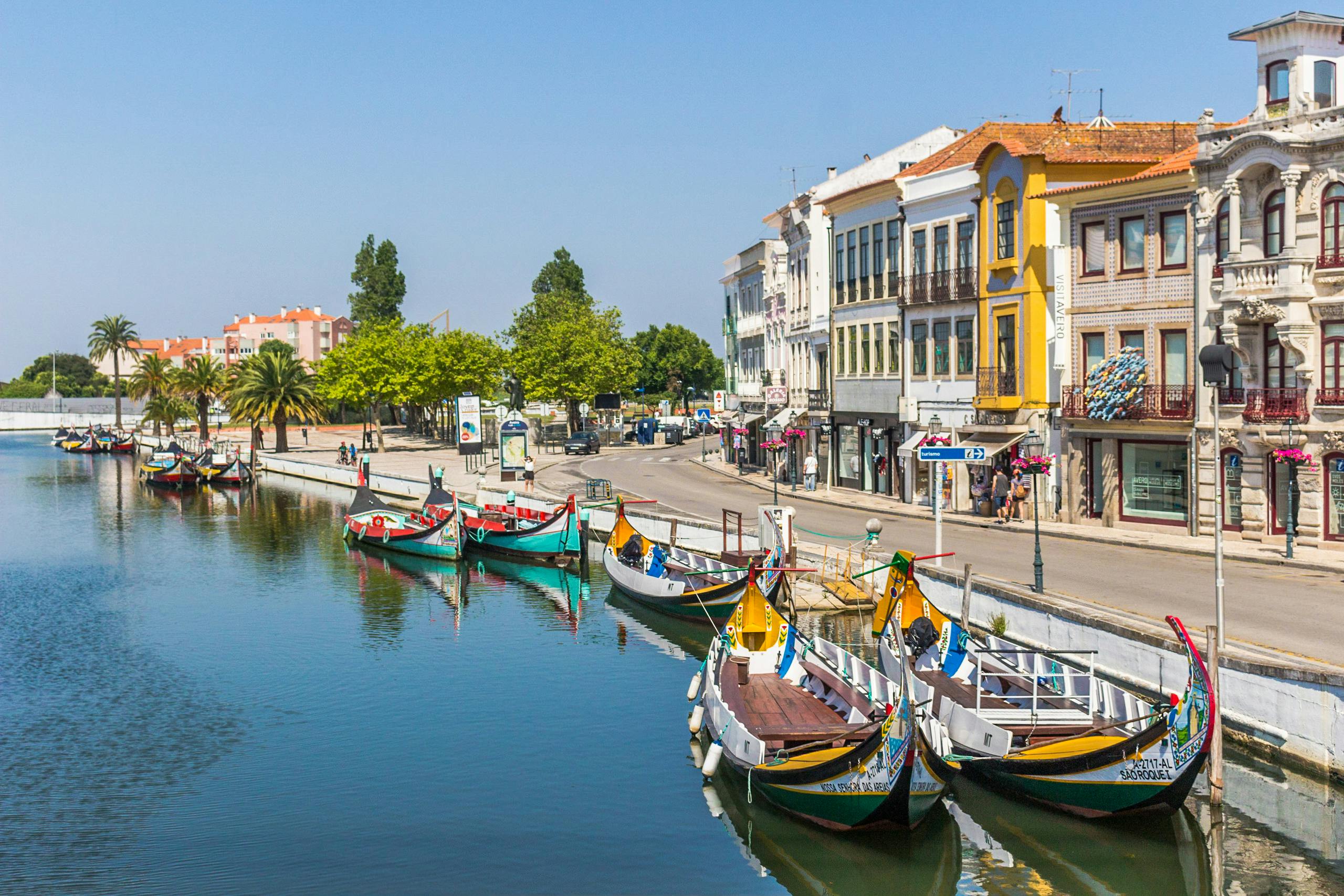 Colorful gondolas along the picturesque canal in Aveiro, Portugal, under a bright sky.