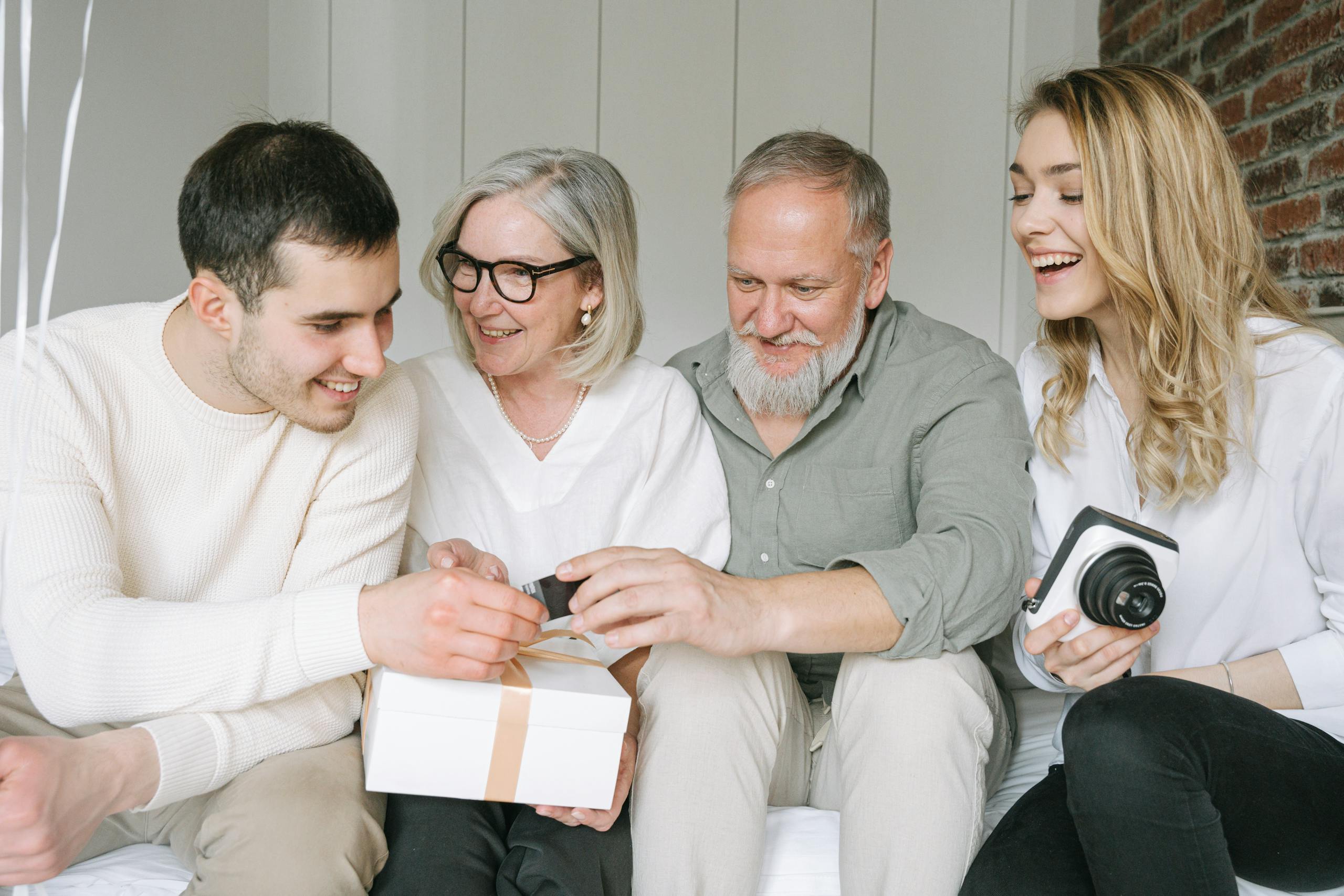 Happy family exchanging gifts together, capturing a joyful moment indoors.