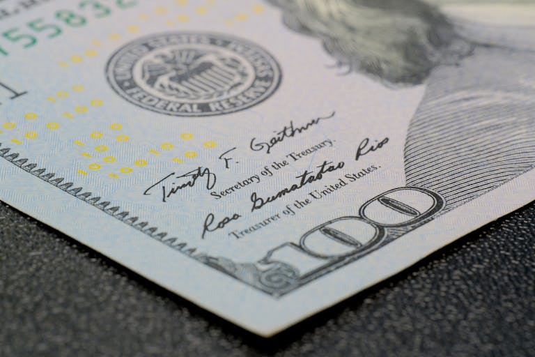 High-resolution close-up of a hundred dollar bill showing intricate security features.