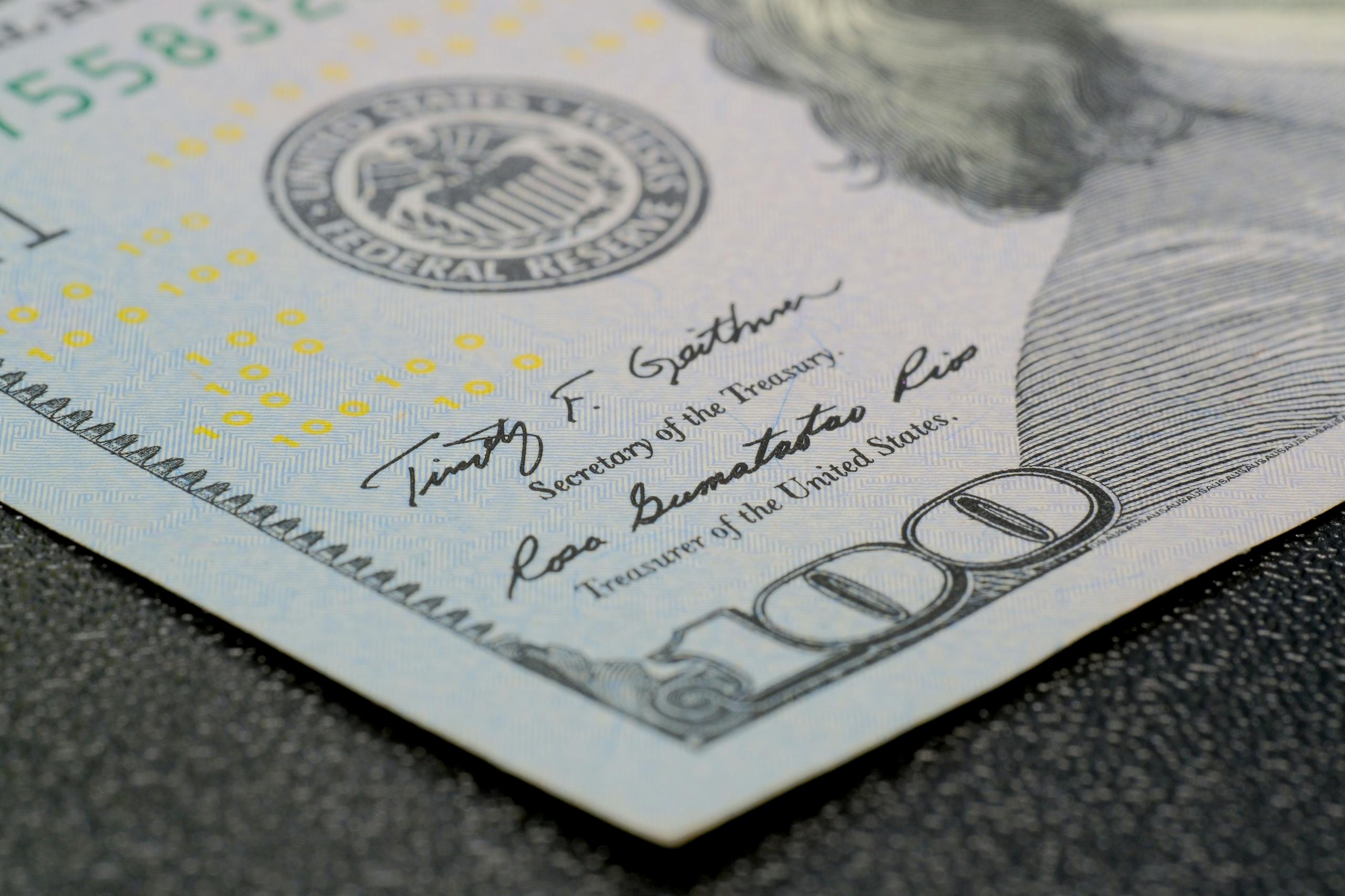 High-resolution close-up of a hundred dollar bill showing intricate security features.
