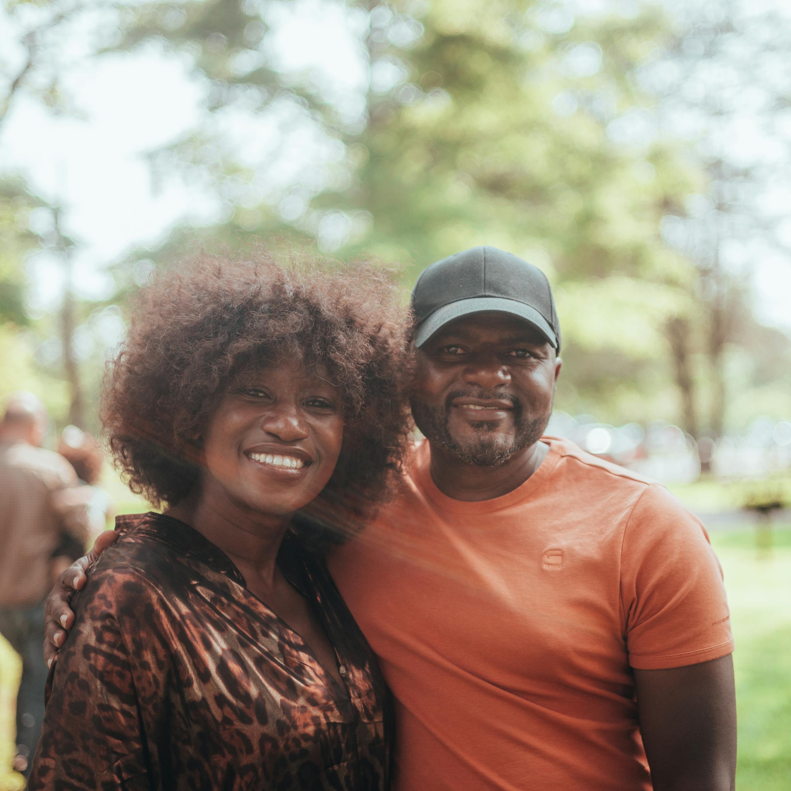Smiling African American couple enjoying outdoor time together in a park setting.