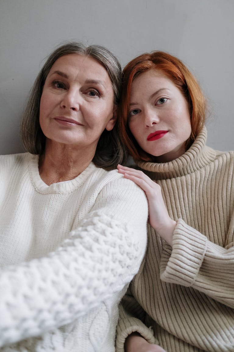 Warm and intimate portrait of a mother and daughter in cozy knitwear, sharing a tender moment.