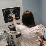 Female doctor conducting an ultrasound screening on a patient in a medical office.