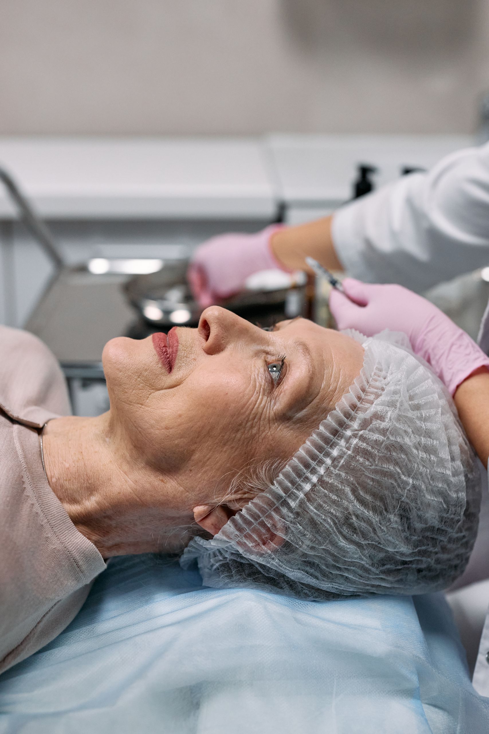 Senior woman receiving facial treatment at a spa, focusing on anti-aging care.
