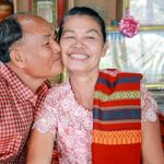 Smiling elderly couple embracing affectionately indoors, showcasing love and togetherness.