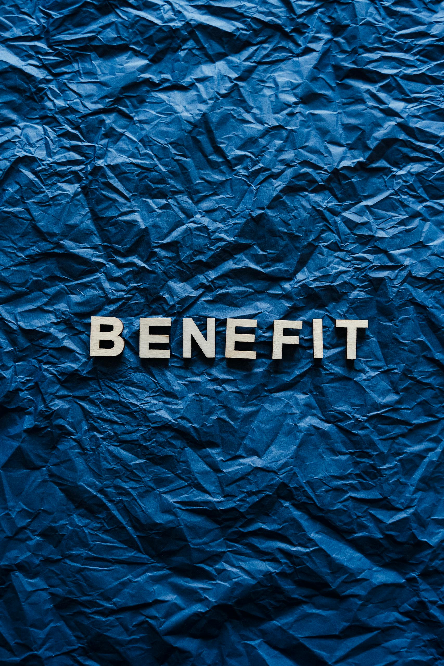 The word 'Benefit' displayed on crumpled blue paper, ideal for concepts.