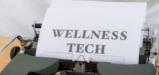 A close-up of a vintage typewriter featuring a paper with the words 'Wellness Tech.'