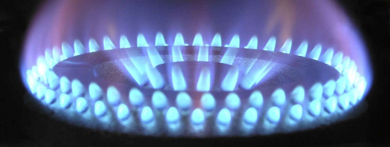 A detailed view of a blue flame on a gas stove, illustrating heat and warmth.