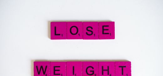 Creative image of the phrase 'Lose Weight' spelled with Scrabble tiles on a white background.