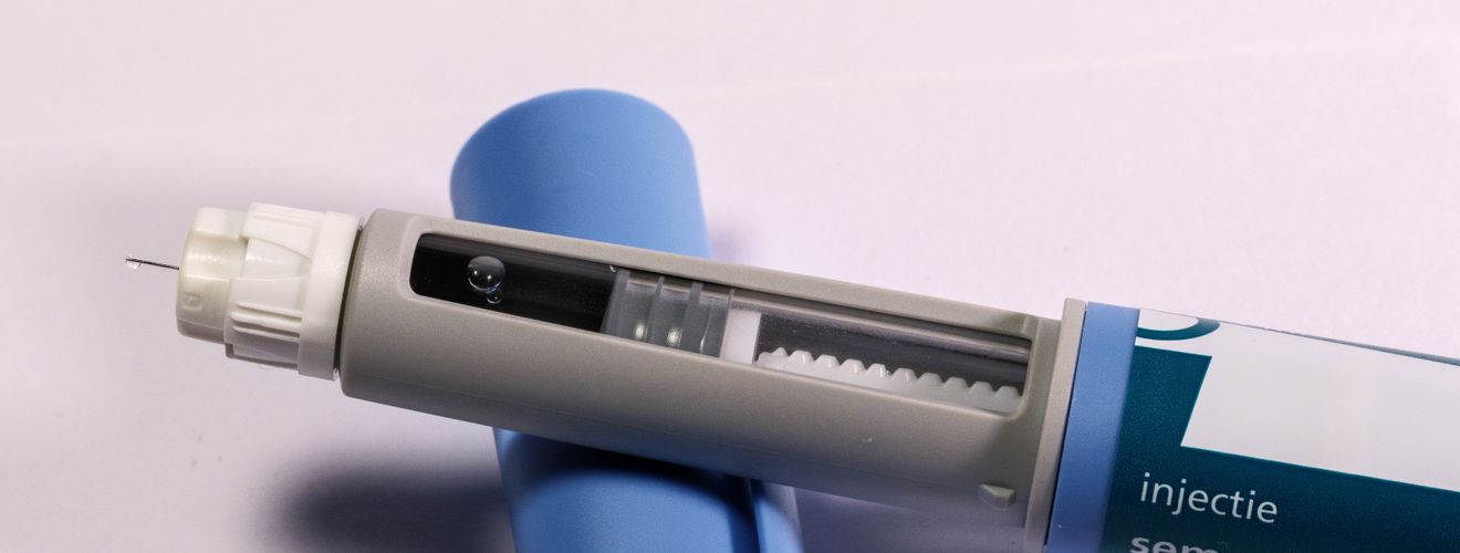 Detailed view of a semaglutide injection pen, commonly used for diabetes treatment, on a plain background.