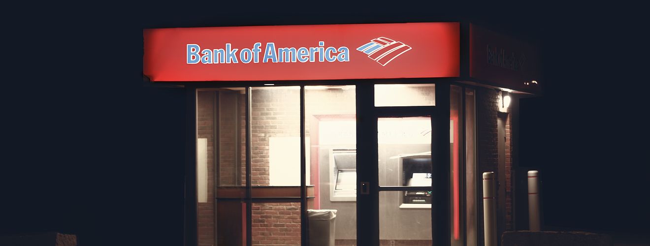 Illuminated Bank of America ATM structure against a dark nighttime backdrop in Boston.