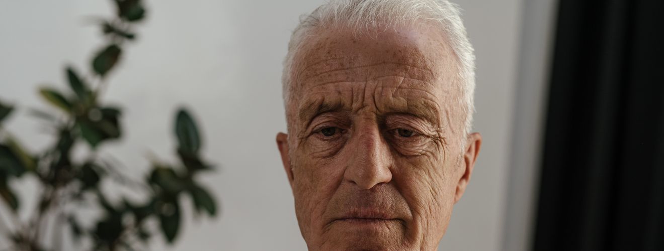 Elderly man concentrating on solving a Rubik's Cube, showcasing focus and mental agility.