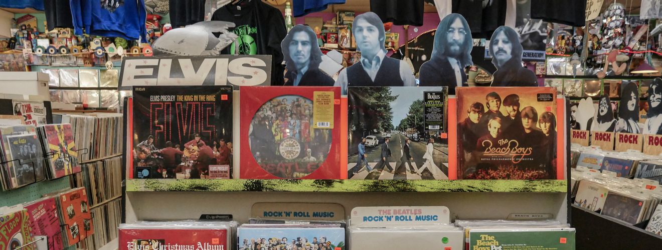 Retro vinyl collection featuring The Beatles and Elvis Presley in a classic music shop.