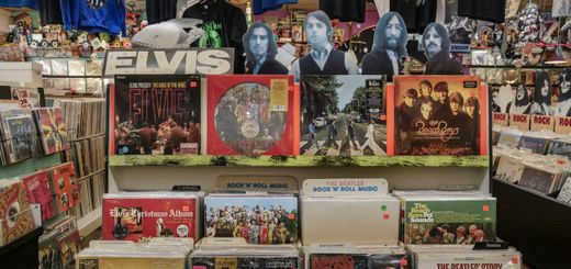 Retro vinyl collection featuring The Beatles and Elvis Presley in a classic music shop.